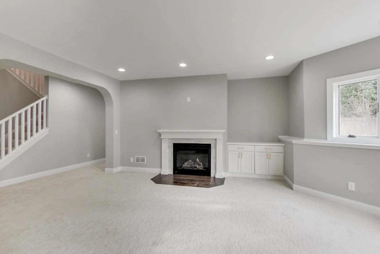 Finished living space with clean carpeting, built-in cabinetry and a fireplace from the KPS archive