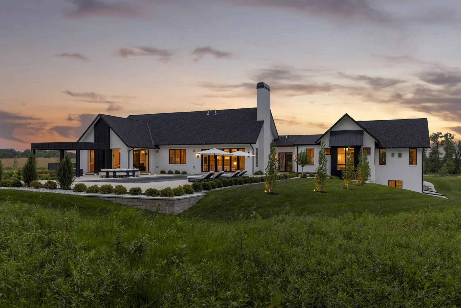 Villa Rococo at dusk, with illuminated gables opening to the surrounding meadow